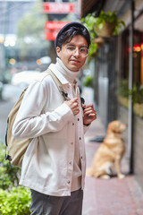 Stylish man wearing white  sweater and jacket  and standing on street