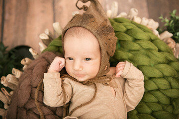 a newborn boy 12 days old in an elf kitten lies in a basket
