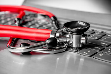 Stethoscope on a computer keyboard. Computer technology is an integral part of medicine, healthcare, and medical health insurance today. Focus on keyboard. Artistic defocus