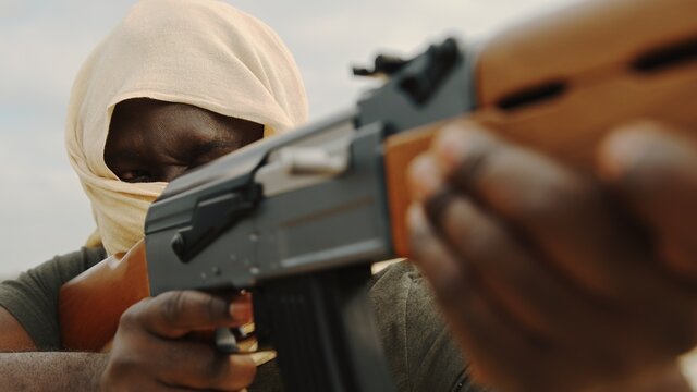 Afro-American with automatic rifle aiming with AK47. High quality photo