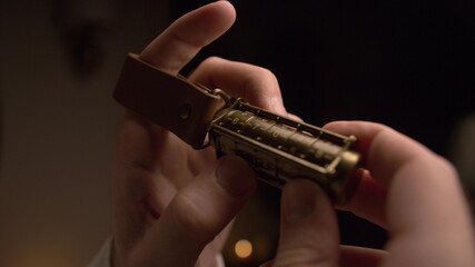 A man holds copper cryptex with numbers.He calculates cryptex code with his hand