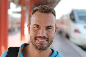 Fototapeta na wymiar Blonde man smiling in train station 