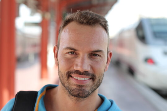 Blonde man smiling in train station 