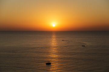 Sunrise over the Gulf of Oman, Arabian See with calm water and fishing boats starting the day. Concept of calm and serenity. Concept of small local sustainable fishing