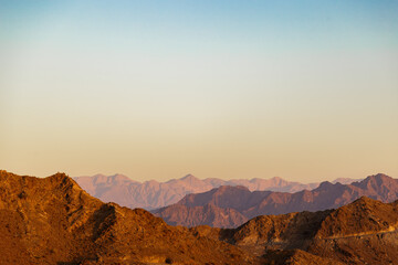 Sunset over Jabal Haqamah pick in Fujairah mountains. Concept of calm and serenity. Concept of wild and dangerous tourism.