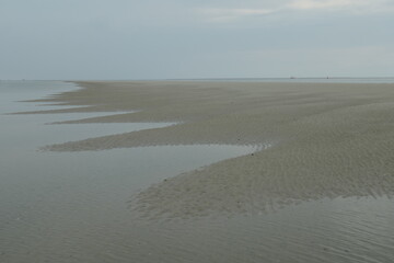 The beach at low tide, wavy lines.