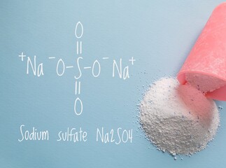 Structural chemical formula of sodium sulfate molecule with laundry washing powder detergent with blue sodium sulfate speckles. Sodium sulfate is mainly used for the manufacture of detergents.