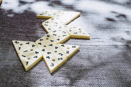 Jeu de strat&eacute;gie avec des pi&egrave;ces en forme de triangle et des chiffres &agrave; aligner