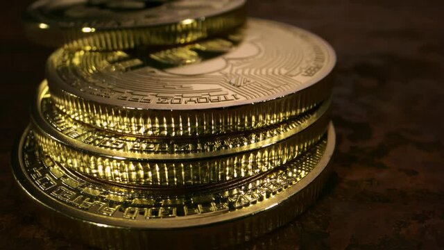 Close up slow motion detail shot of bitcoins falling and stacking on top of each other.