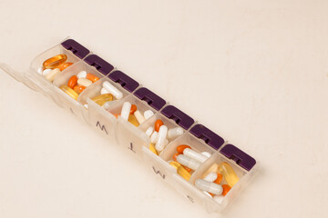 Daily pill box full of vitamins and medications and supplements 