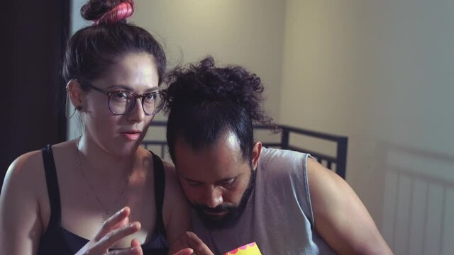 Pareja de novios casados comiendo palomitas viendo televisi&oacute;n pel&iacute;cula en casa terror miedo