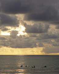 Naklejka na ściany i meble The silhouette group of surfers waits for the waves at Kuta beach, Bali.