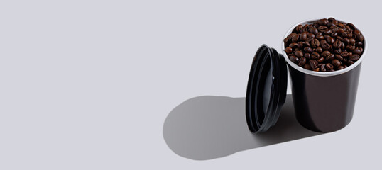 disposable black Cup with coffee beans on white background, banner