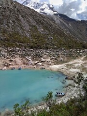 Boats at Laguna Paron, Huaraz, Peru. A blue-green lake in the Cordillera Blanca on the Peruvian Andes. At 4185 meters above sea level, it's surrounded by snowy peaks and a pyramid mountain. 