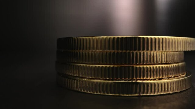 Super slow motion shot on the edge of Bitcoins as they fall, stacking on top of one another.