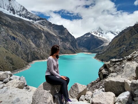 Girl at Laguna Paron, Huaraz, Peru. A blue-green lake in the Cordillera Blanca on the Peruvian Andes. At 4185 meters above sea level, it's surrounded by snowy peaks and a pyramid mountain. 