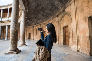 Tourist young woman in Carlos V palace, in "La Alhambra".Granada, Spain.