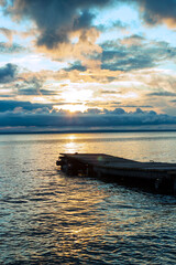 fishing wooden pier in Onega lake against the backdrop of the sunset sky on a quiet summer evening