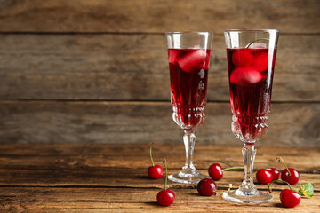 Delicious cherry wine with ripe juicy berries on wooden table. Space for text