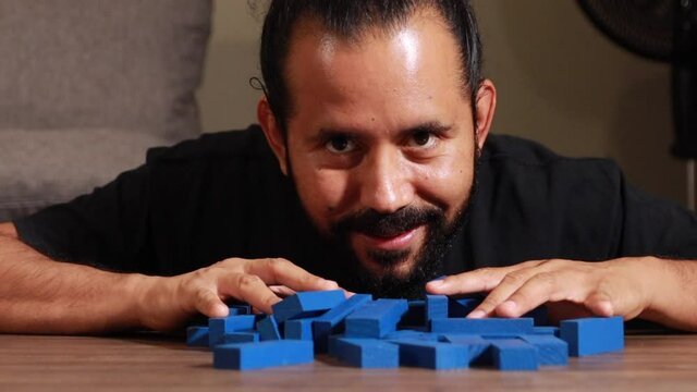 Hombre lanza fichas de juego de mesa jenga apilados divertido