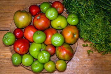 Organic green, red, yellow, orange tomatoes on wooden table