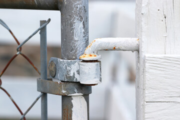Close up shot of rusty metal hinge of old gate
