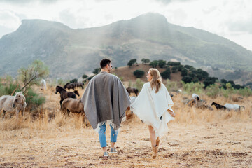 couple in poncho walking in the mountains