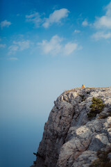 
Girl sitting in a hat on a rock thinking