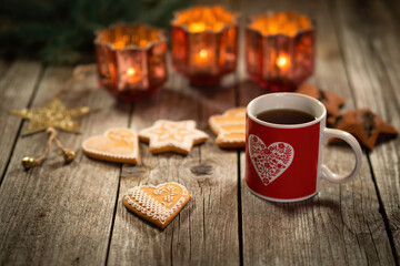 Homemade Christmas mulled wine punch with gingerbread on wooden rustic table. Burning candles in background. Traditional autumn and winter hot drink. Close-up