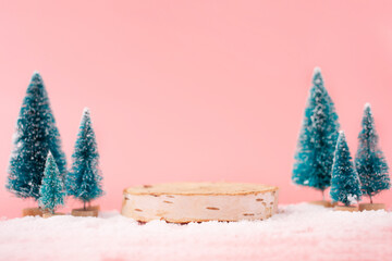Mock up with wooden podium from a circle of wood on trendy pastel pink background with christmas...