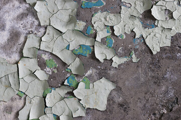 Peeling paint on the wall. Old concrete wall with cracked flaking paint. Weathered rough painted surface with patterns of cracks and peeling. High resolution texture for background and design. Closeup