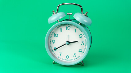 Alarm clock isolated beginning time 02.40 am or pm. on green background, Time concept..