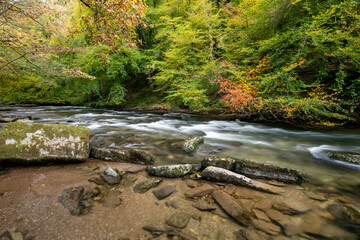 Long exposure of the river Barle flowing through the Barle Valley at Tarr Steps in Exmoor National Park