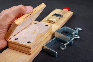 Gluing pieces of wood with carpentry glue. Minor carpentry work in the workshop.