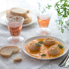 Pan Seared Sea Scallops with Orange Tomato Sauce. Glass of Rose Wine