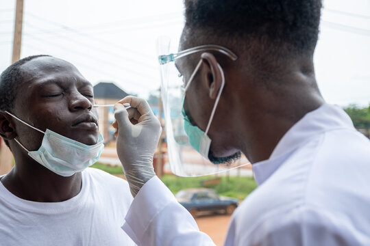 black lab scientist taking nasal sample from a man