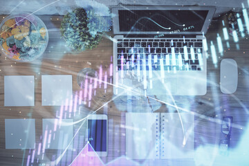 Stock market graph and top view computer on the table background. Multi exposure. Concept of financial education.