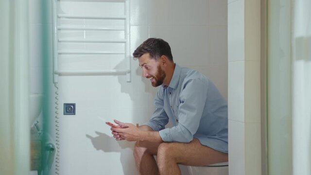 Happy businessman use phone sitting on the toilet smiling mobile restroom. Vlogger influencer around social media, app icons animation loud with white interface. Slow motion