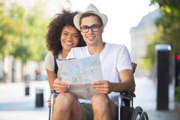 happy tourist in wheelchair with girlfriend