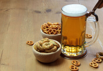 Beer in a mug and pretzels on a wooden background