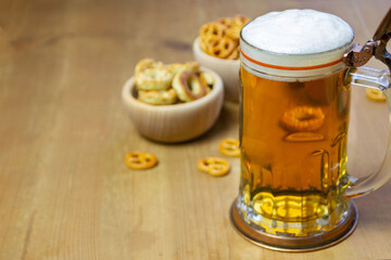 Beer in a mug and pretzels on a wooden background