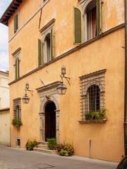 Fototapeta na wymiar Fachada con entrada antigua con columnas en un edificio en Spoleto, Italia, verano de 2019.