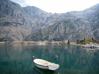 White boat on smooth sea water against the backdrop of mountains