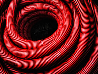 Tubo rojo enroscado en espiral con fondo negro