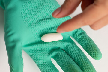 Patient taking rectal suppository from doctor's hand in gloves (selective focus)