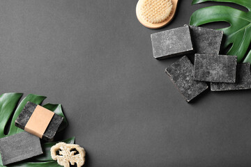 Flat lay composition with natural tar soap on black background. Space for text