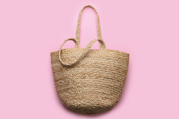 Fototapeta premium Elegant woman's straw bag on pink background, top view