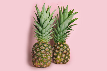 Whole ripe juicy pineapples on pink background