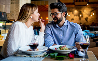 Paste and red wine. Young couple enjoying lunch in the restaurant. Lifestyle, love, relationships, food concept