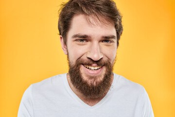 Obraz premium Man with emotional expression white t-shirt close-up studio yellow background